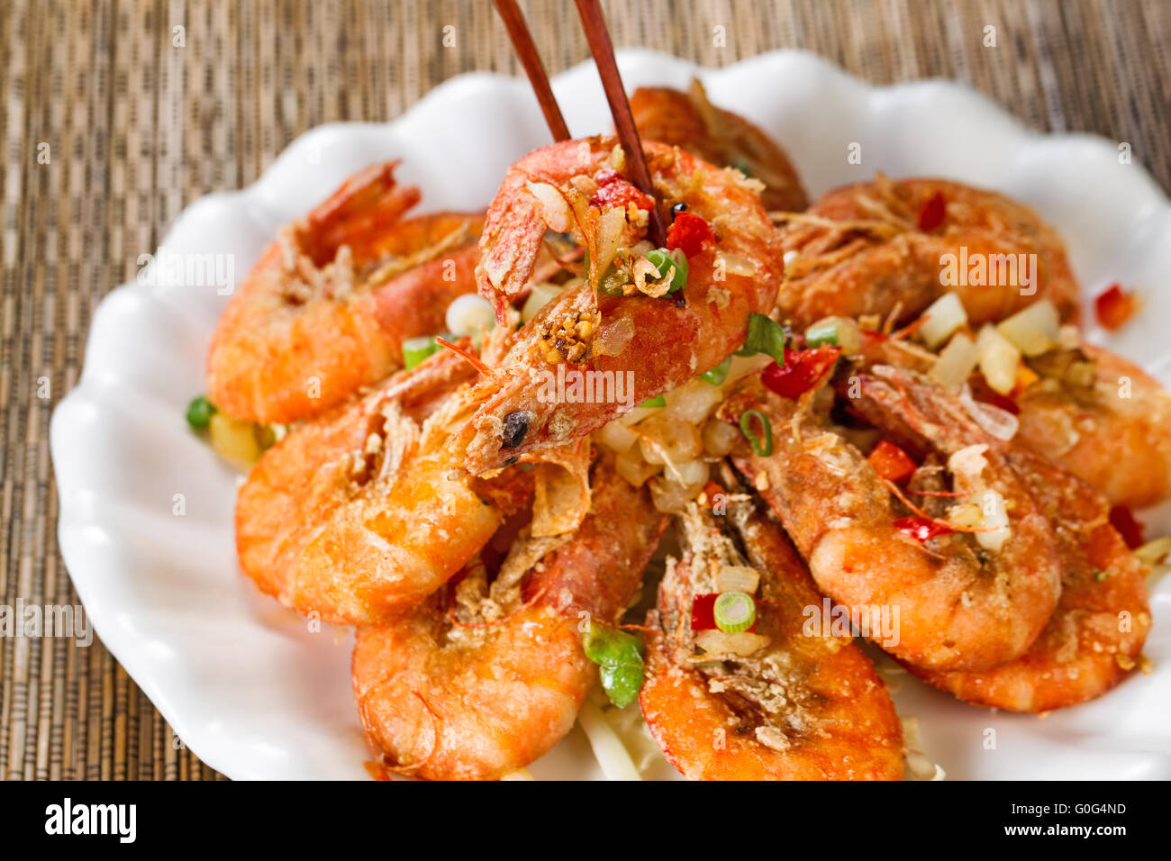 Fried bread coated shrimp and garnishes on white serving plate ready to eat Stock Photo
