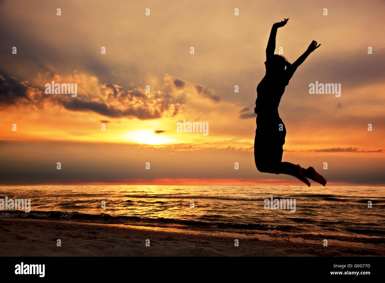 Happy woman jumping on the beach at sunset. Success Stock Photo Alamy