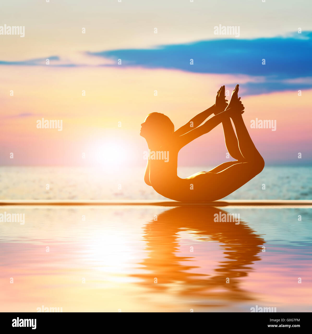 A silhouette of a woman in bow yoga position Stock Photo