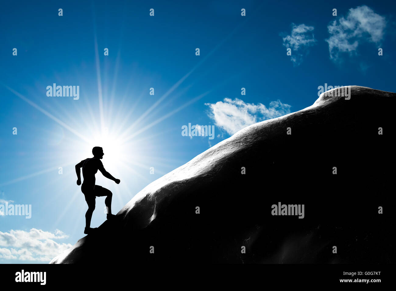 Silhouette of a man running up hill to the peak of the mountain. Trekking Stock Photo