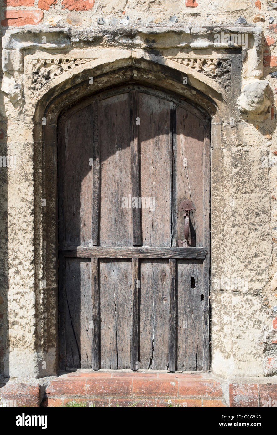 An old wooden door with stone surround in the wall of a church in ...