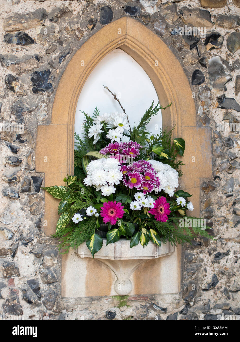 A bouquet of flowers in a church wall. Stock Photo