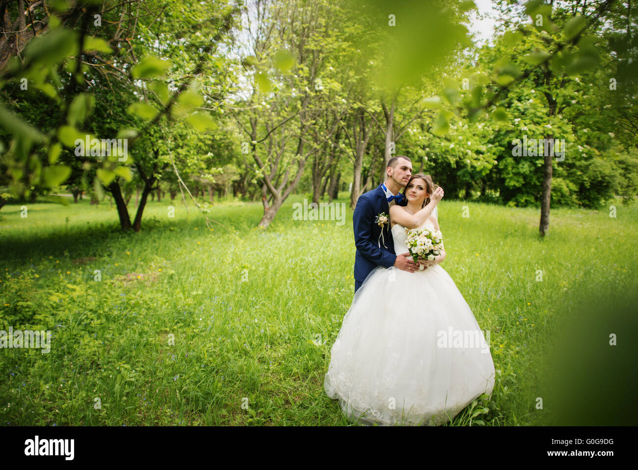 Young lovely and cheerfull wedding couple walking at the park Stock Photo