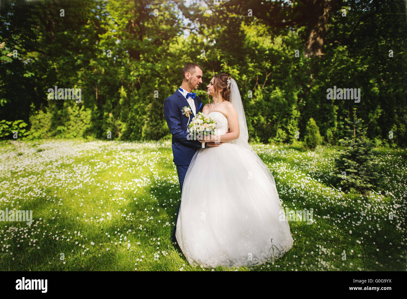 Young lovely and cheerfull wedding couple walking at the park Stock Photo