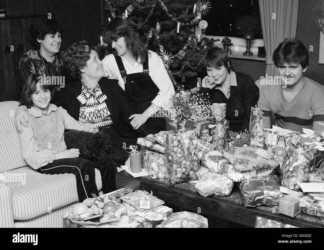 Seventies, black and white photo, festive season, Christmas, Christmas Eve, Christmas tree, festive mood, group of people 10 to 70 years, familiy sitting in the living room, many Christmas presents in gift wrapping paper on the table, pleasure and satisfaction, Frieda, Doris, Monika, Frank, Birgit, Andrea Stock Photo