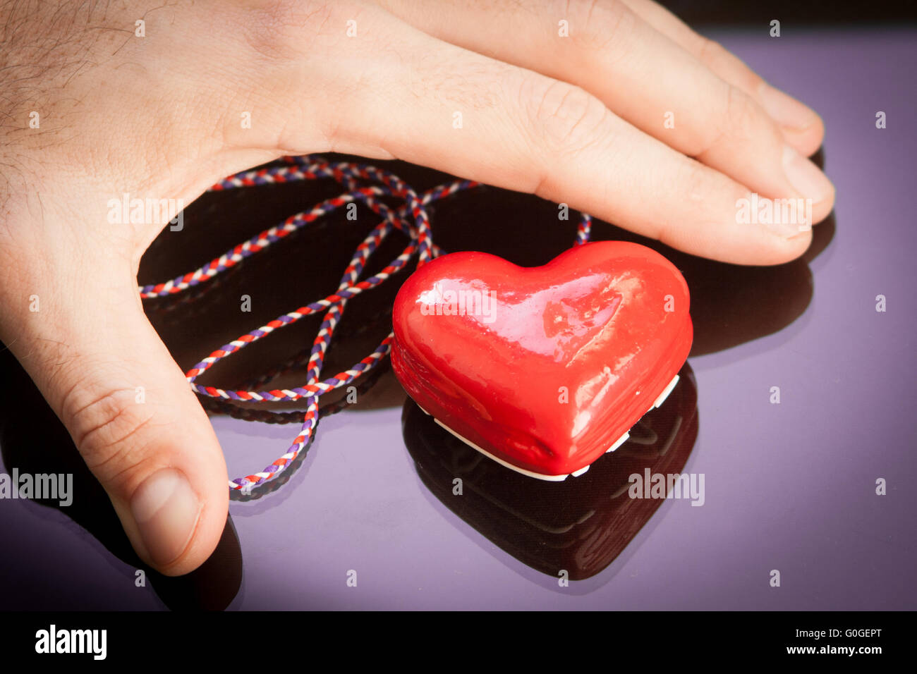 man's hand holding a red heart Stock Photo - Alamy
