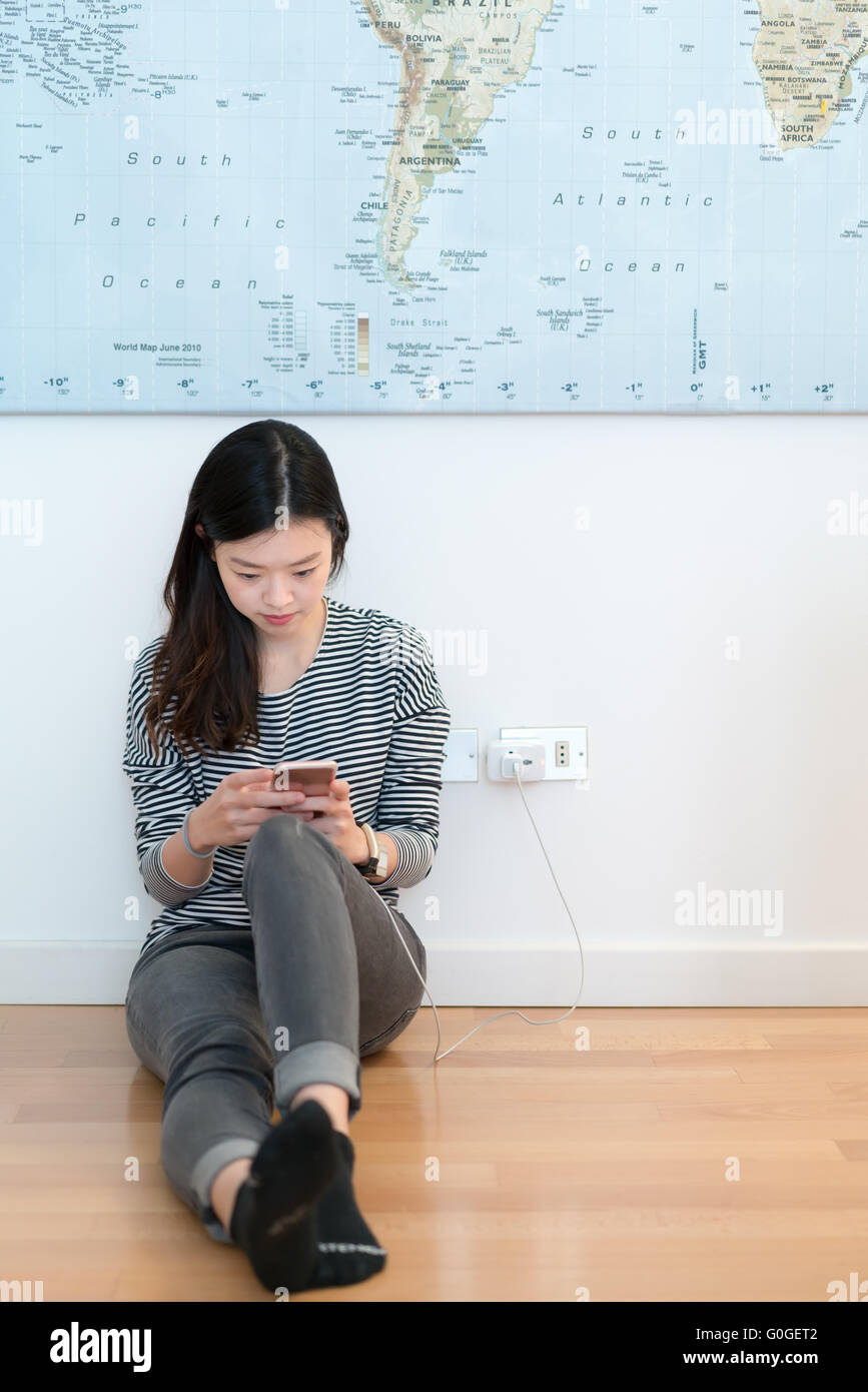 Cute asian girl using smartphone while charging Stock Photo Alamy