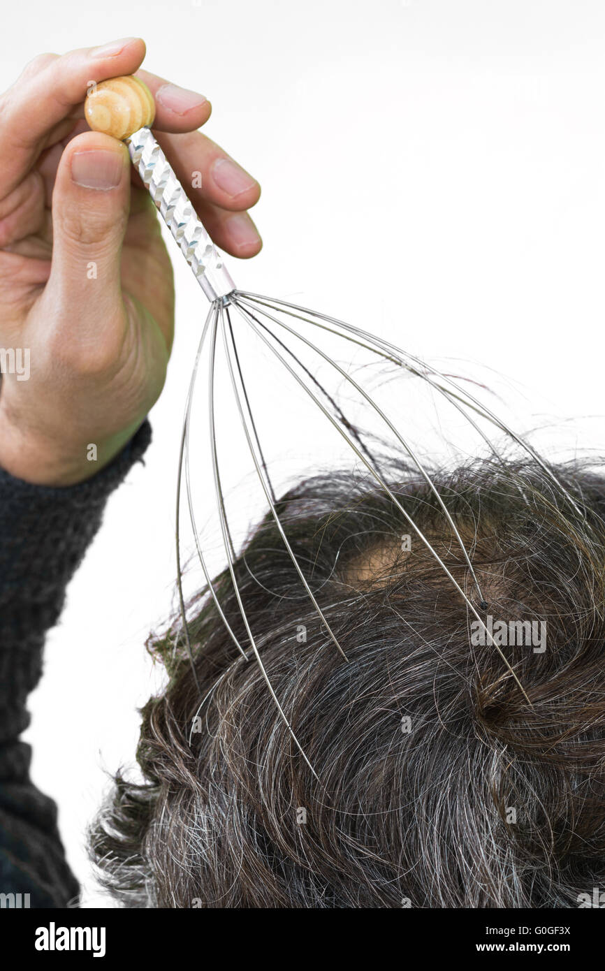 Man relaxes with the Genie head massager. Alternative Therapy. Indian head  massage tool, self head massager Stock Photo - Alamy