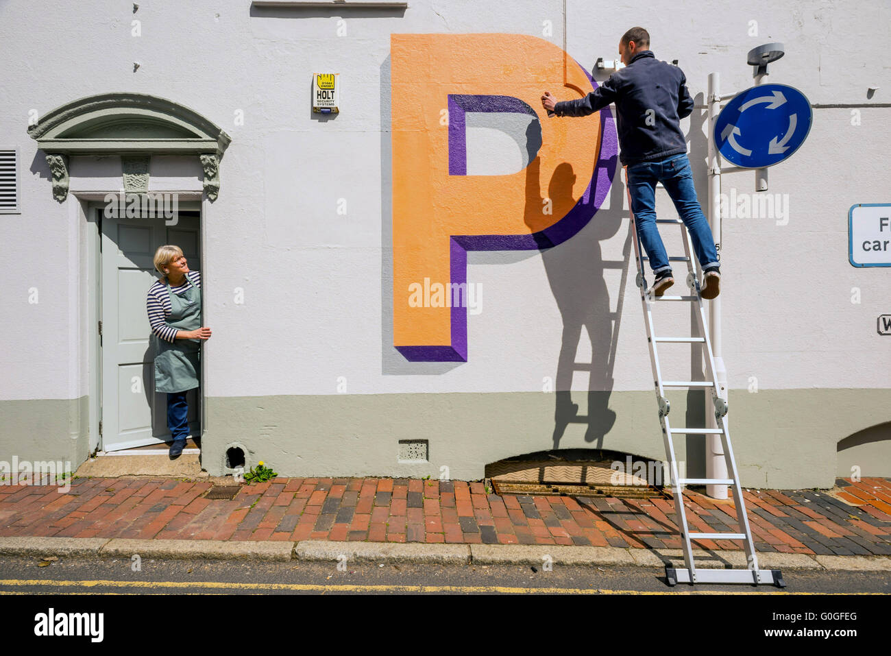 Celebrating 100 years of London Underground's world famous typeface, artist Gary Stranger paints letters on walls in Ditchling. Stock Photo