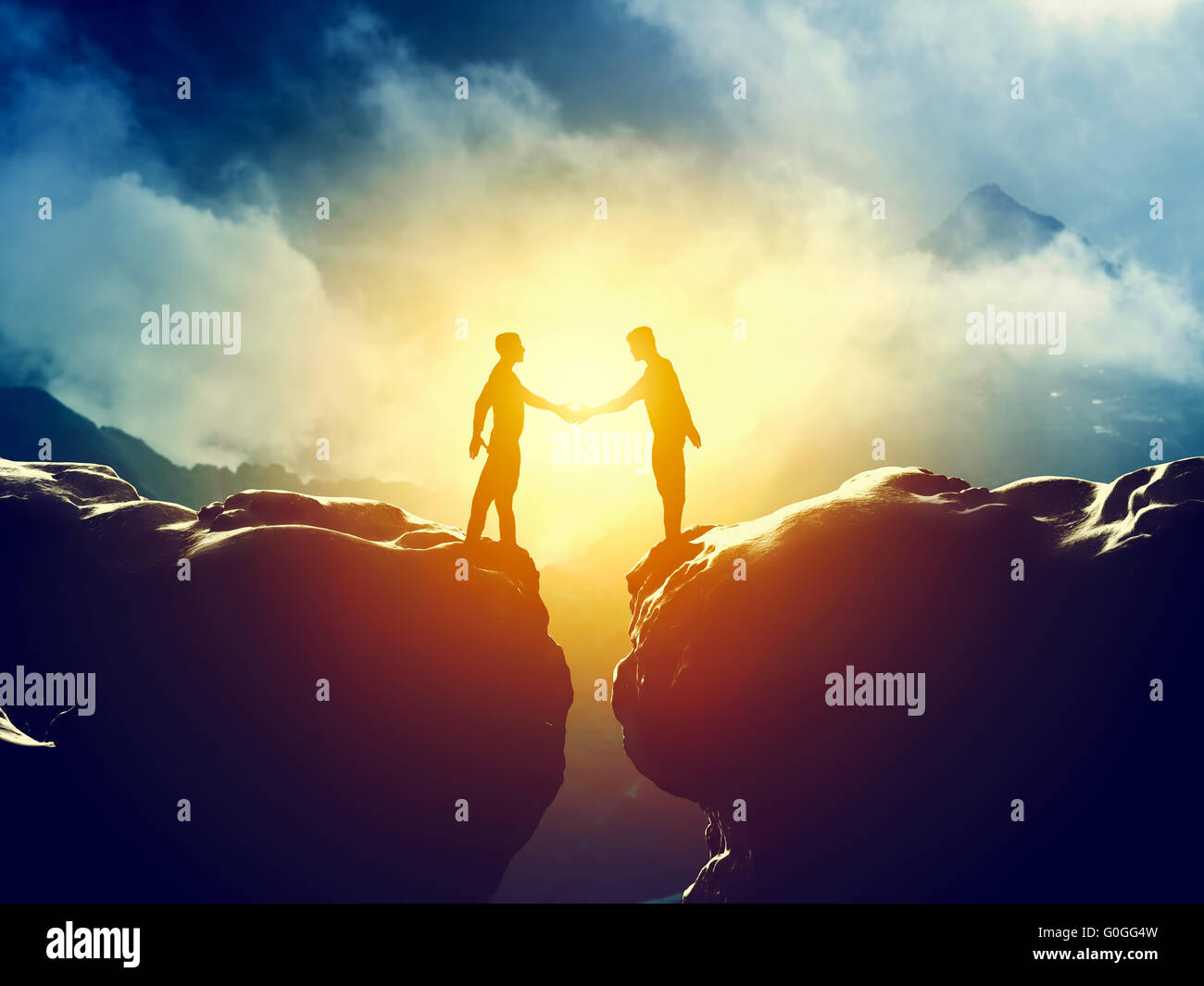 Two men handshake over mountains precipice. Business Stock Photo