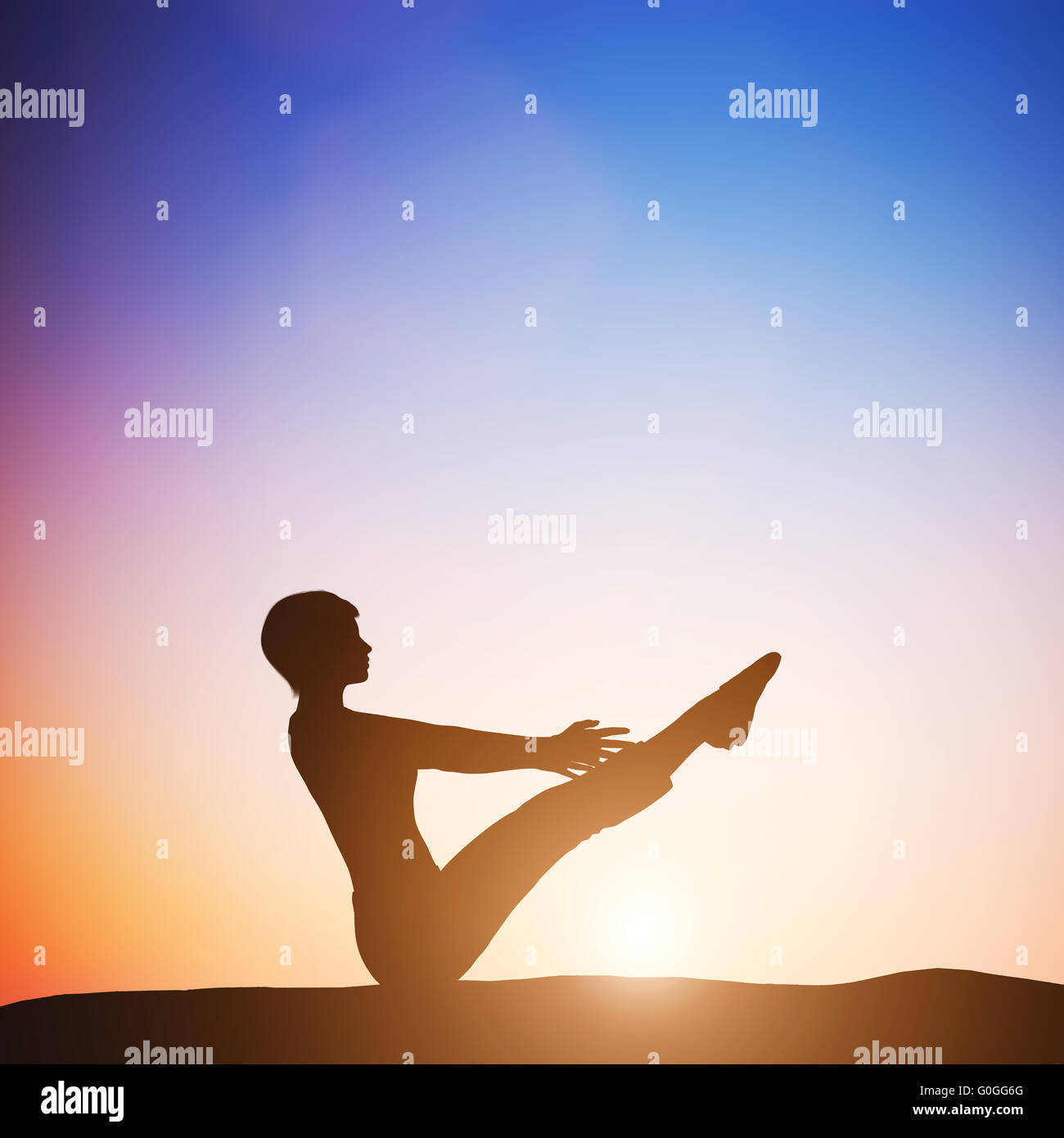 Woman in full boat yoga pose meditating at sunset. Zen Stock Photo