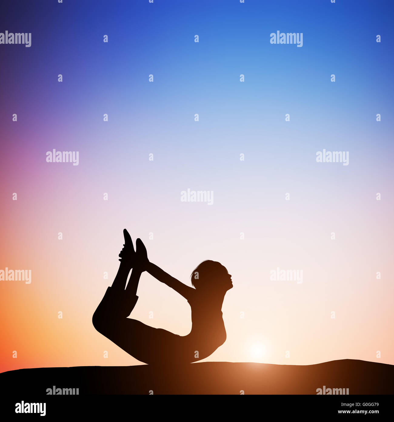 Woman in bow yoga pose meditating at sunset. Zen Stock Photo