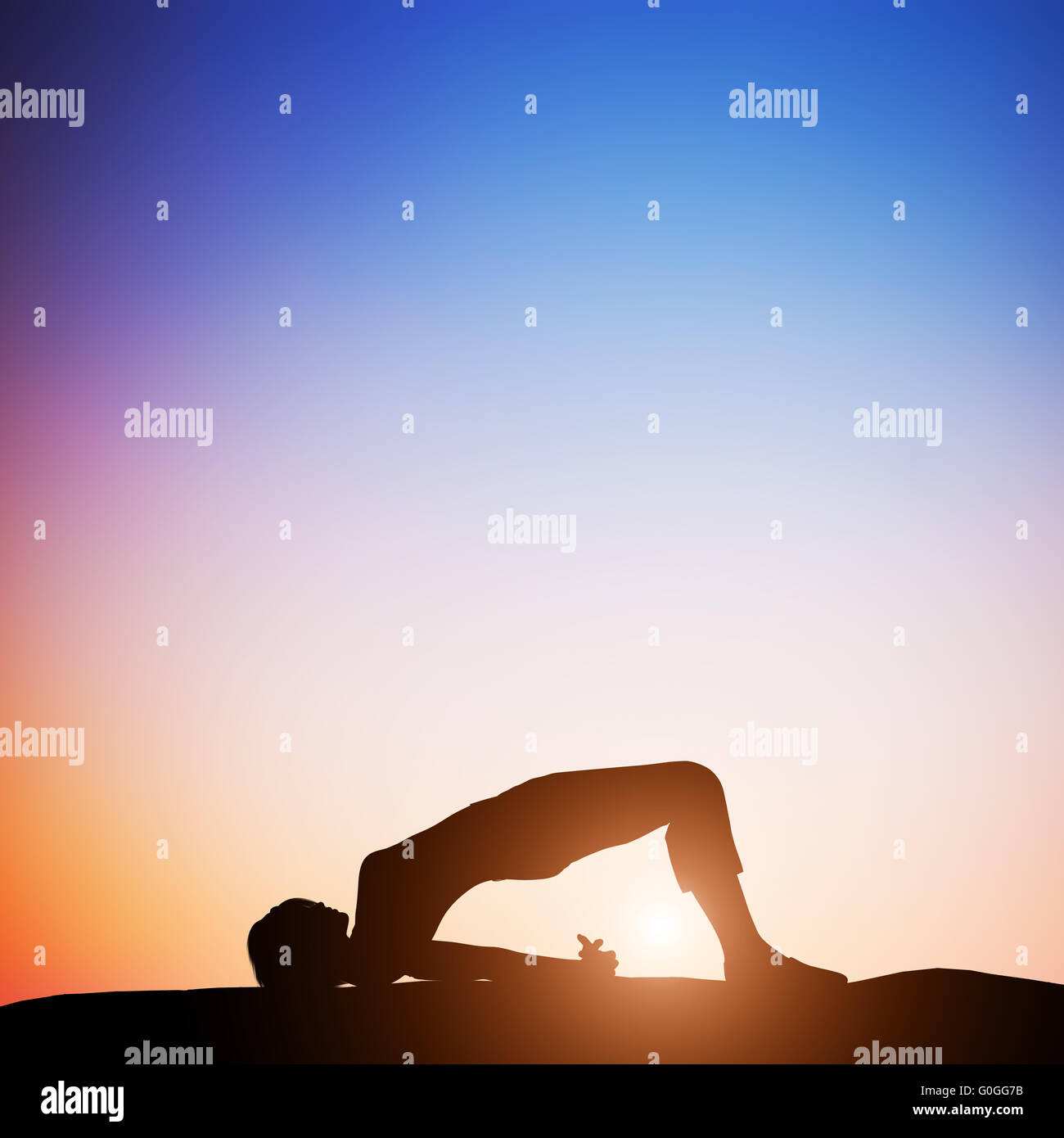 Woman in bridge yoga pose meditating at sunset. Zen Stock Photo