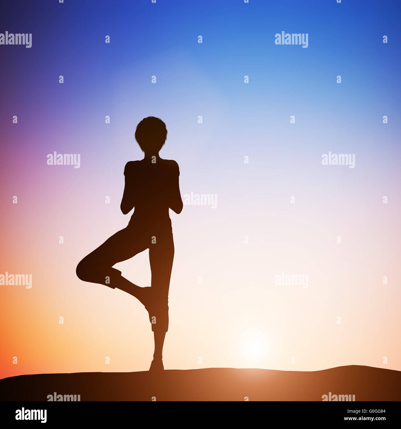 Woman in tree yoga pose meditating at sunset. Zen Stock Photo