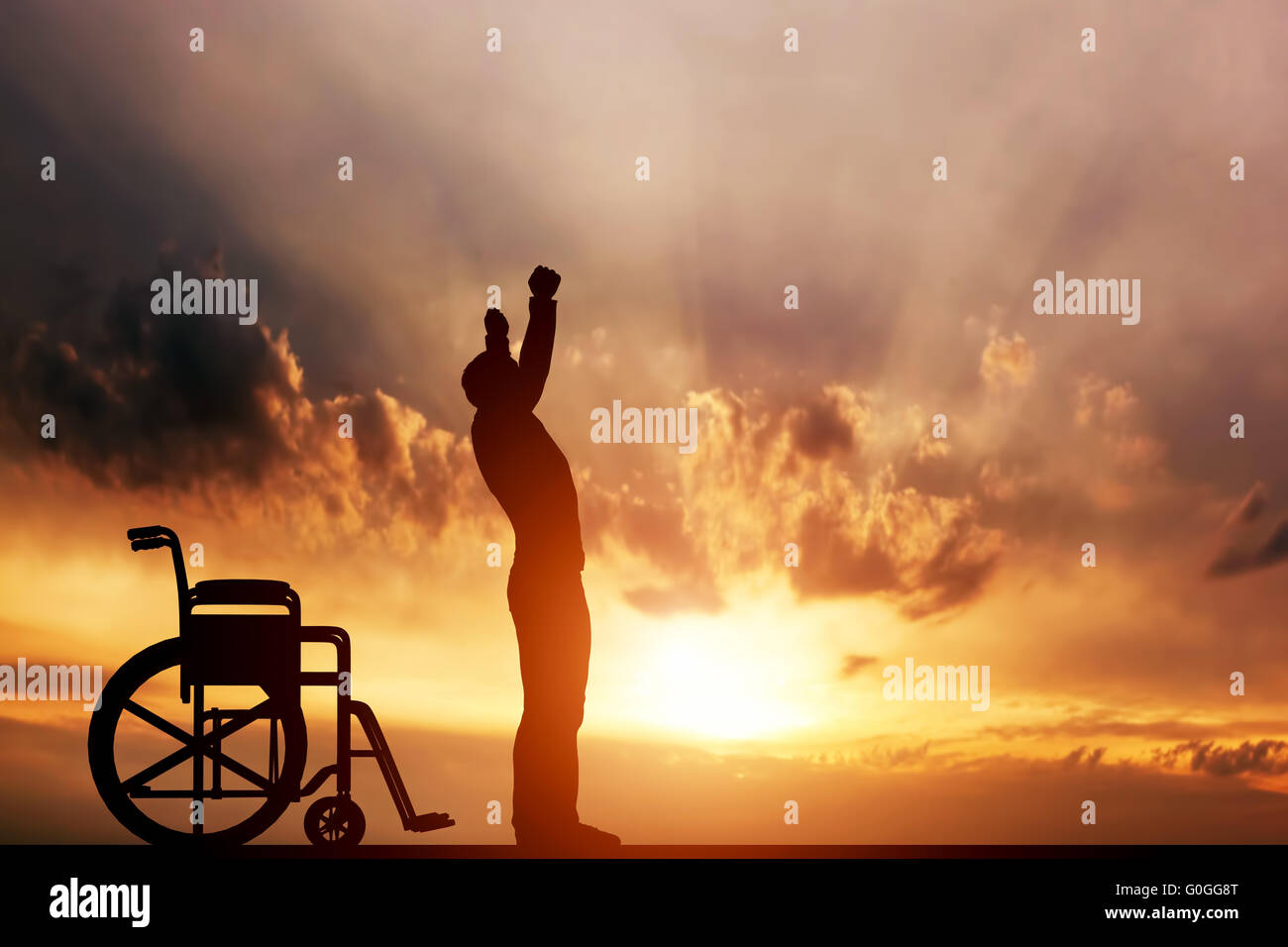 A disabled man standing up from wheelchair at sunset. Positive concept of cure Stock Photo