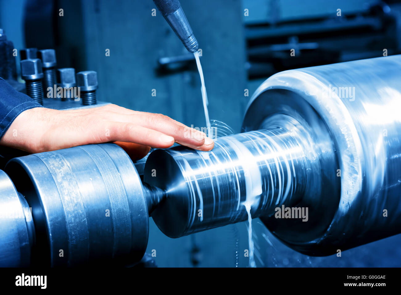 Worker measuring on industrial turning machine. Industry Stock Photo