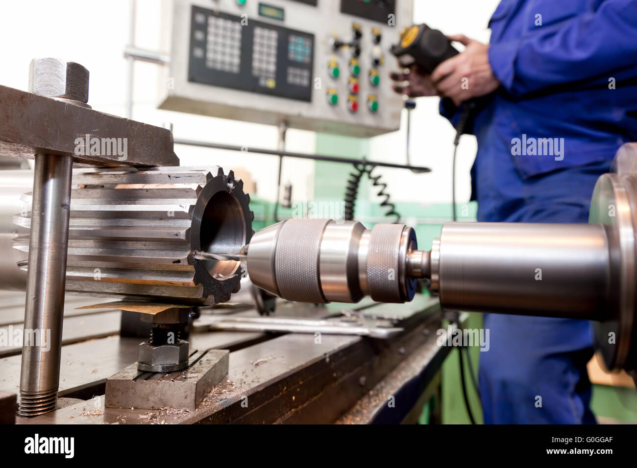 Man operating CNC drilling and boring machine. Industry Stock Photo