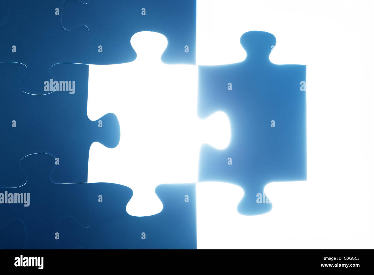 Jigsaw puzzle piece missing. Light glow from empty space. Search for the solution Stock Photo