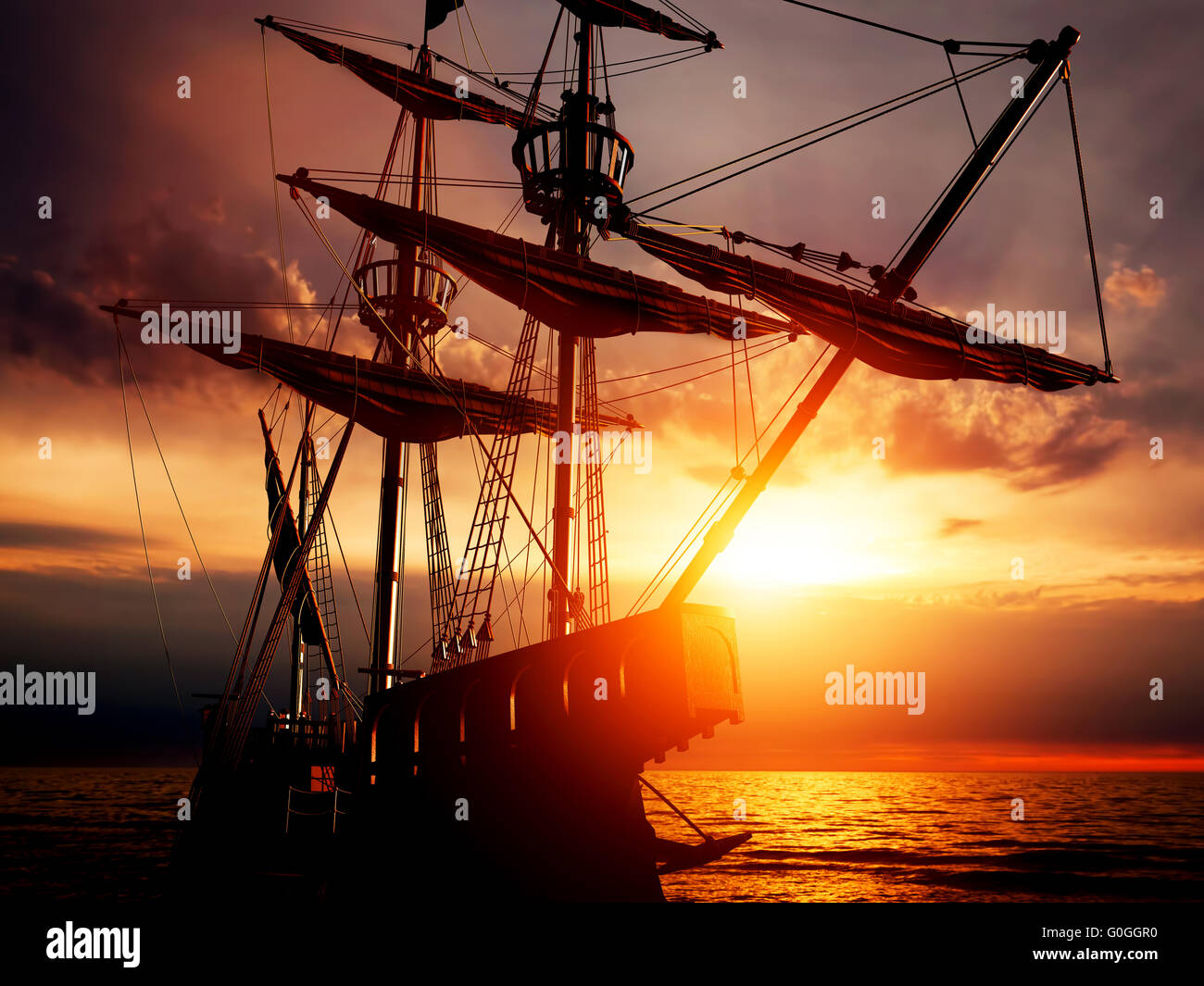Old ancient pirate ship on peaceful ocean at sunset. Stock Photo