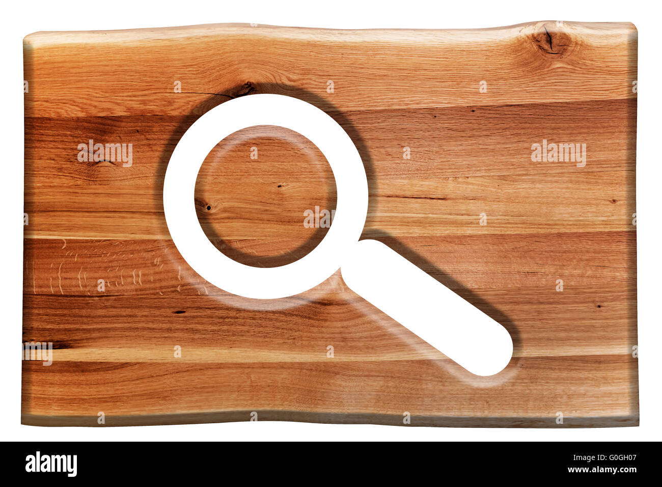 Magnifying glass symbol cut in wooden board isolated on white. Stock Photo