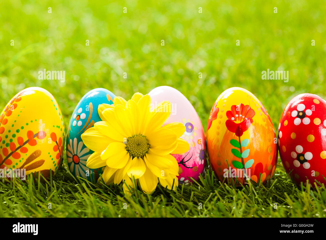 Colorful hand painted Easter eggs and spring flowers in grass Stock Photo