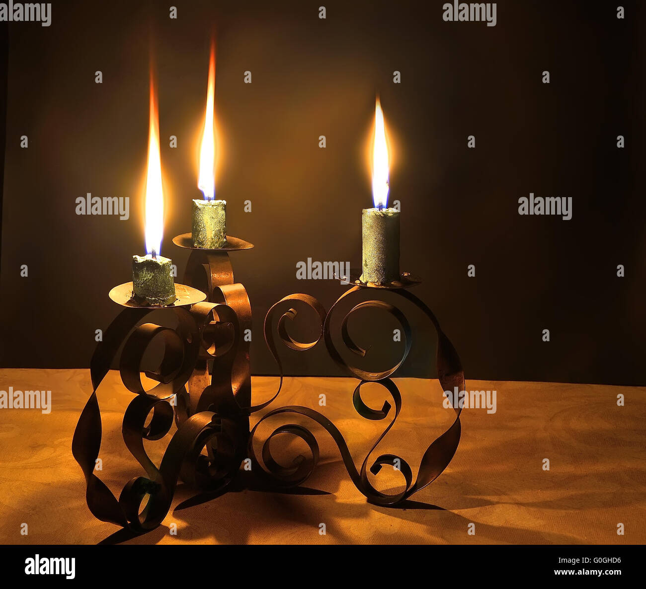 Three burning candles in a candlestick Stock Photo - Alamy