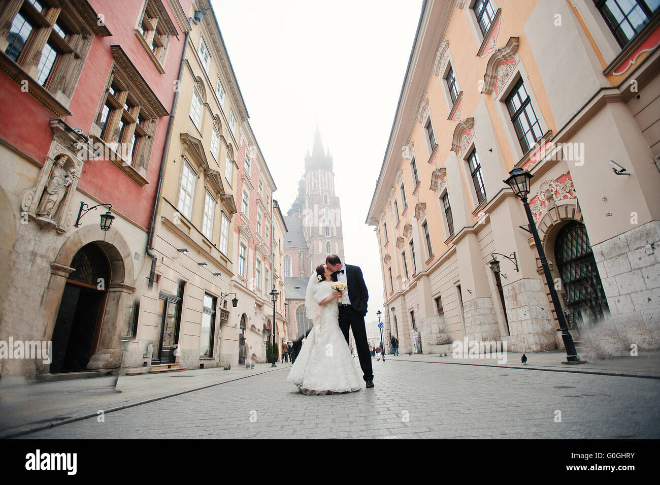 Young elegant and hearty wedding couple in love on streets of Krakow, Poland Stock Photo