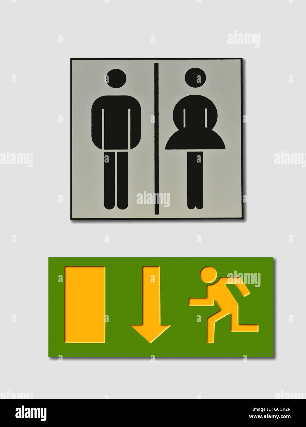 toilette sign with female and male symbol and an escape route indicator Stock Photo