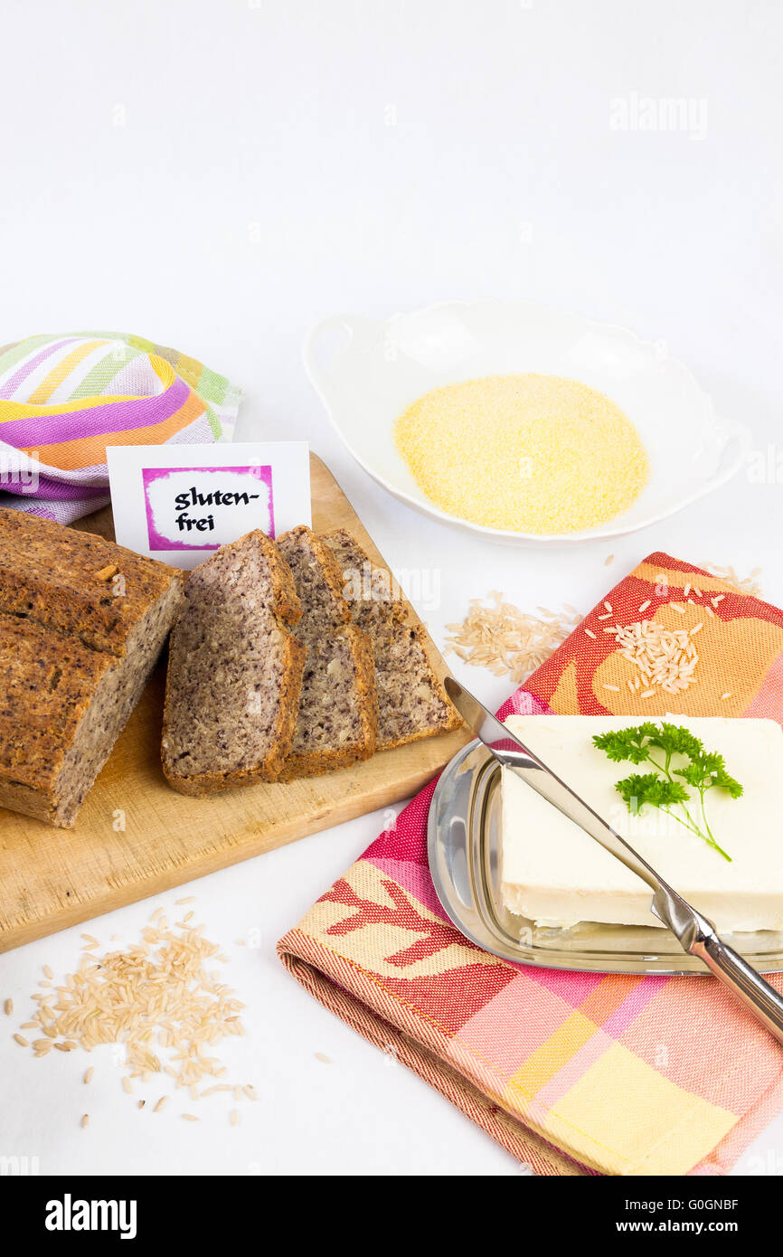 Wooden board with homemade, gluten-free wholemeal bread from rice and corn, served with butter, isol Stock Photo