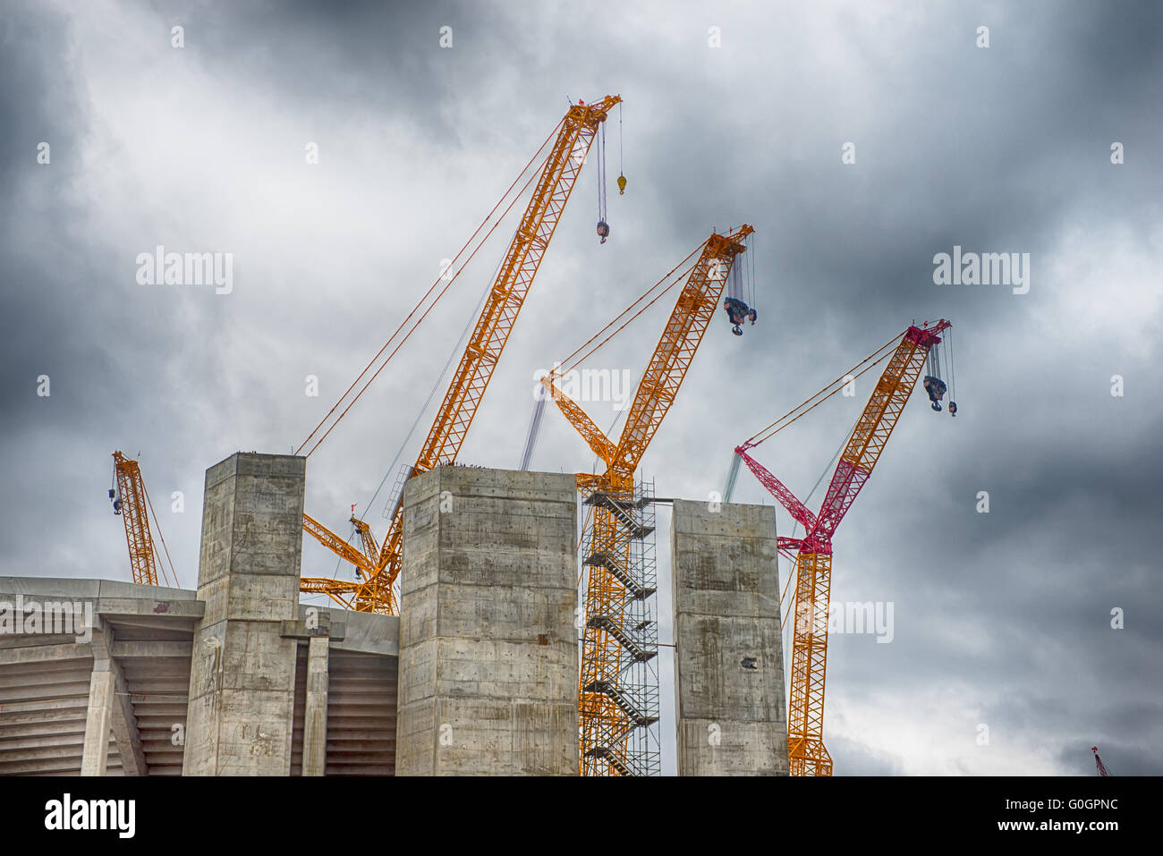 heavy construction cranes erecting concrete building Stock Photo