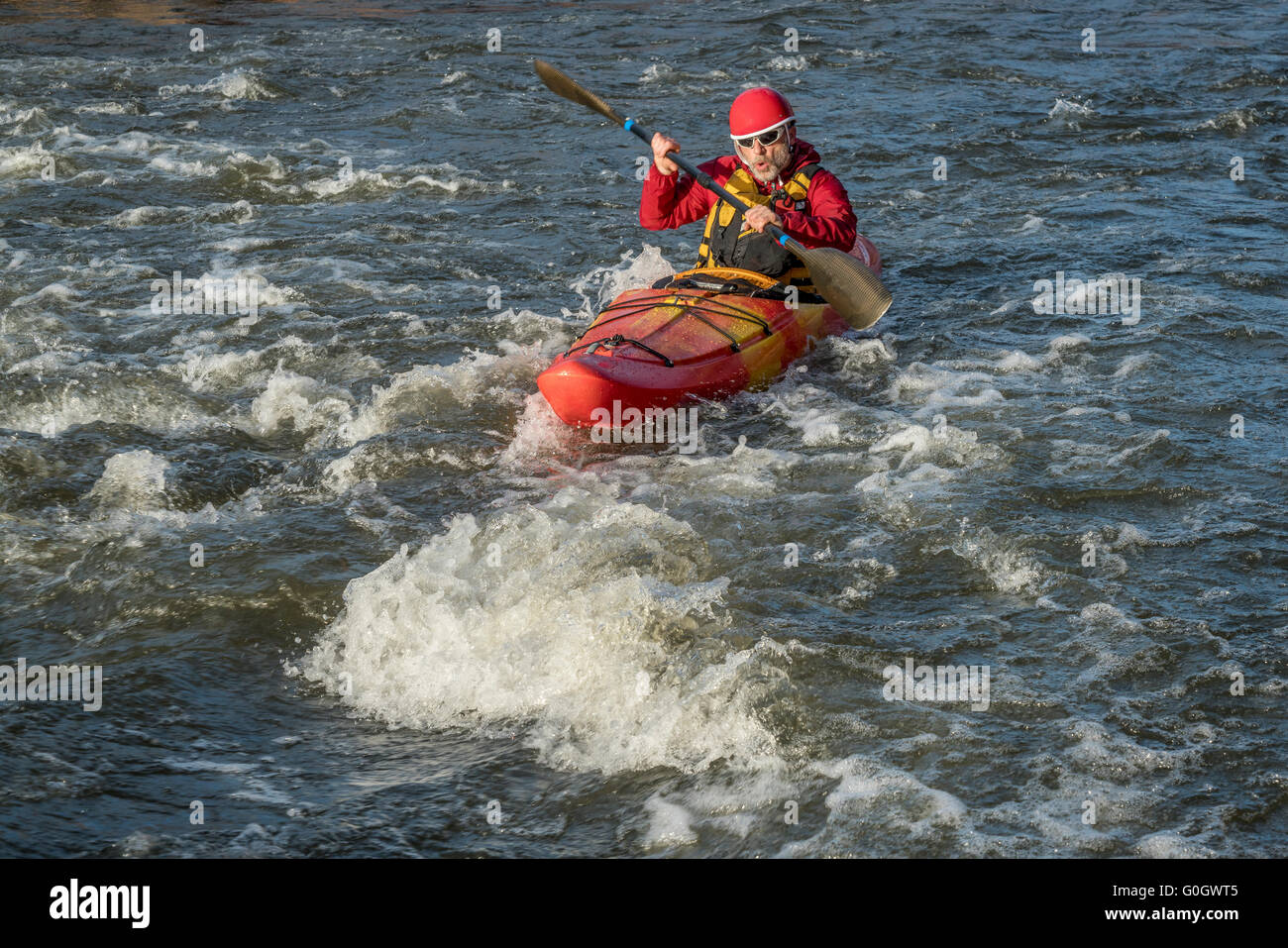 whitewater kayaker paddling upstream the river rapid Stock Photo