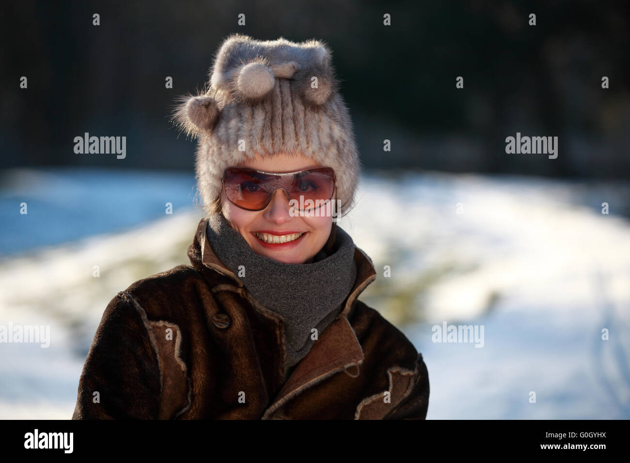 Beautiful girl with sunglasses, bobble hat and buckskin jacket Stock Photo
