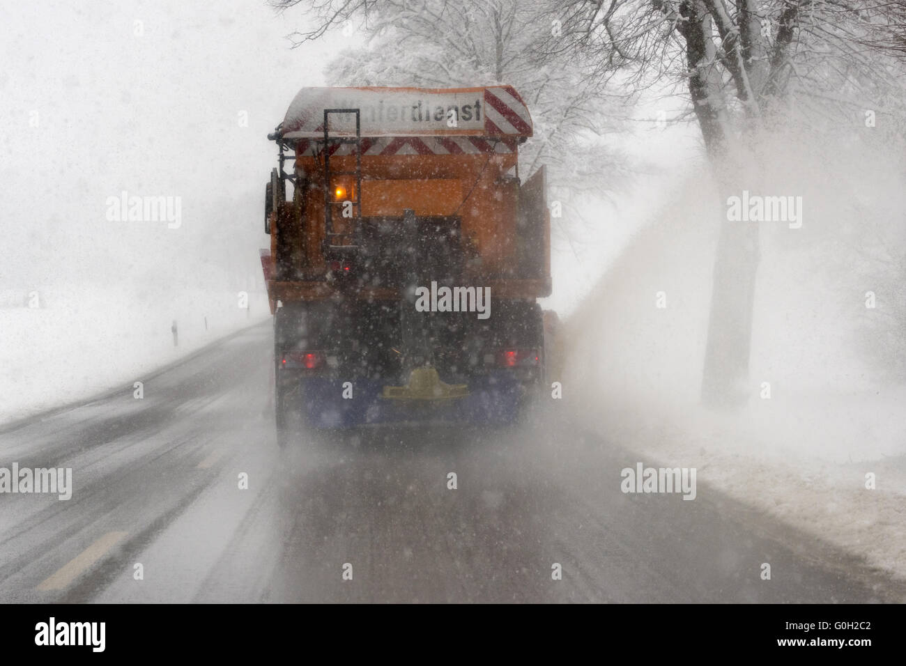 winter service with truck on road with snow Stock Photo