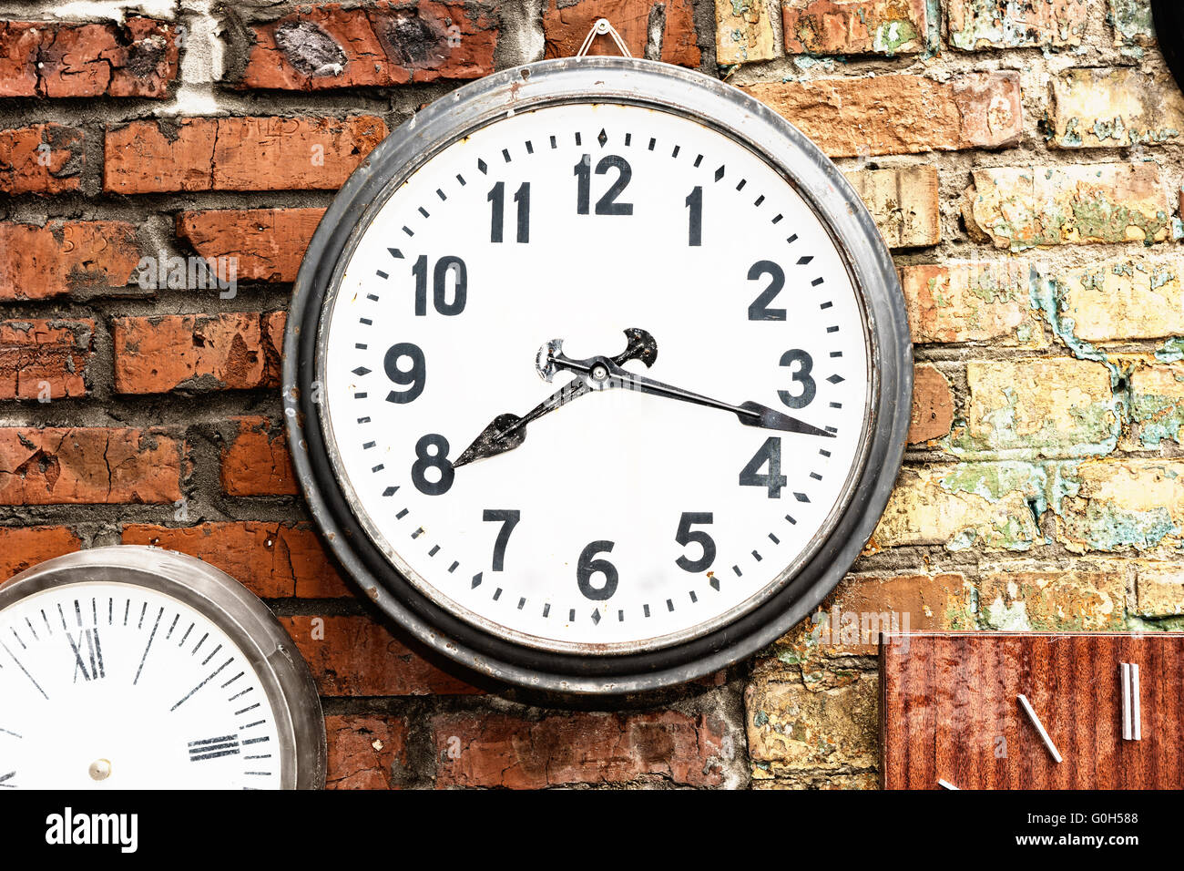 Close Up Of Clock Hanging On Exterior Brick Wall Displaying Time Of 