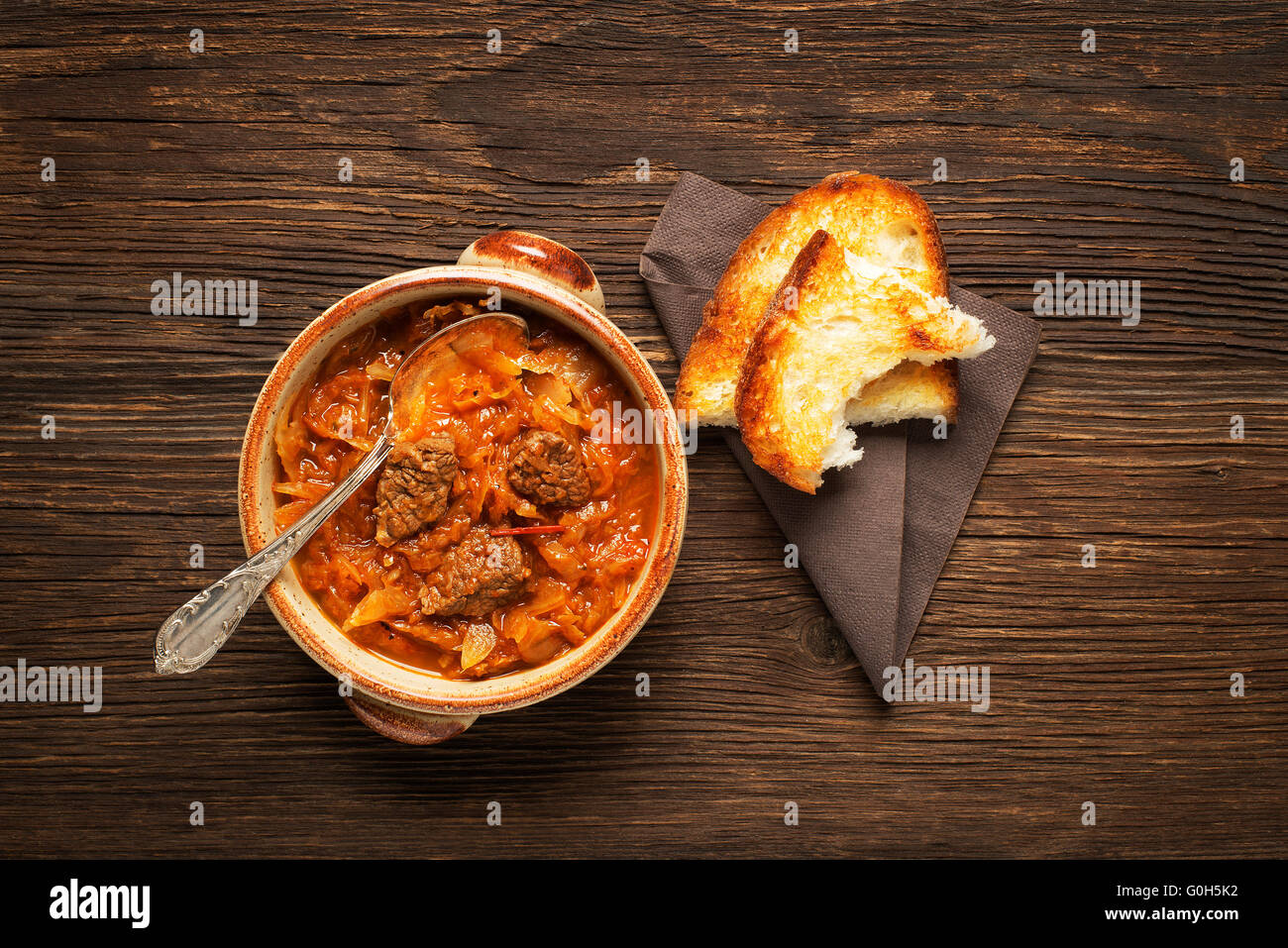 Goulash cabbage with beef on wooden background. Stock Photo