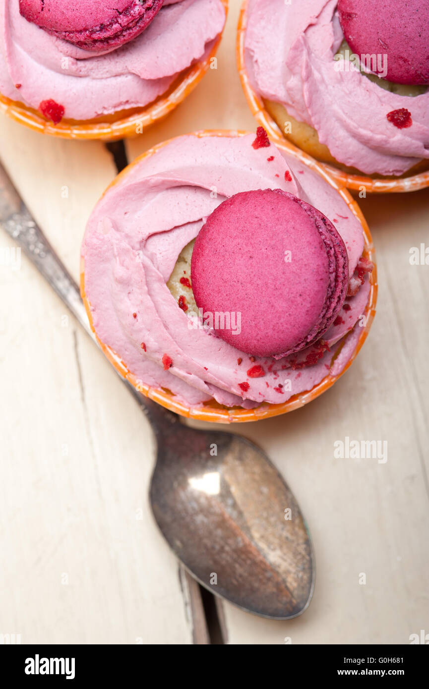 pink berry cream cupcake with macaroon on top Stock Photo