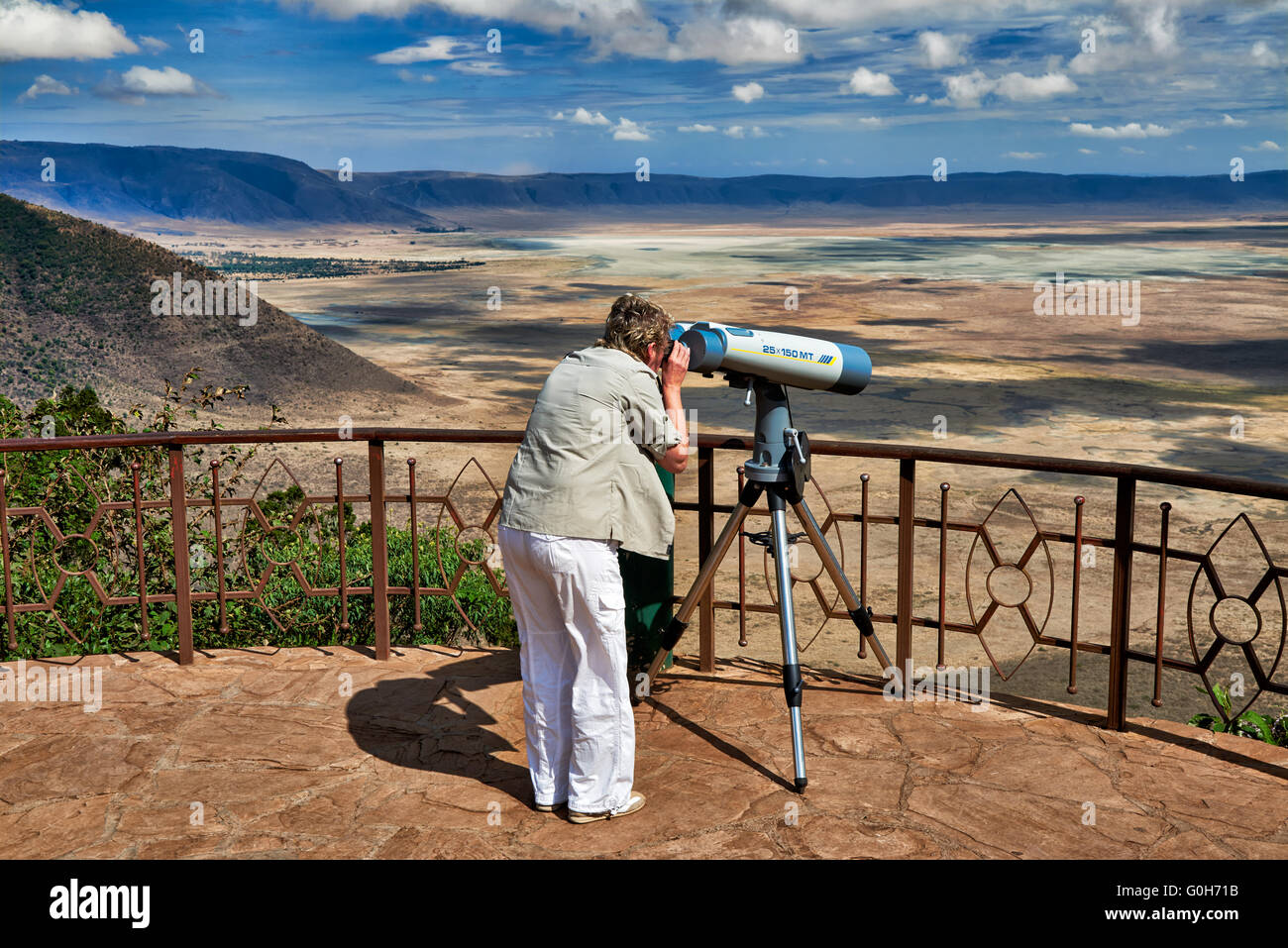 tourist with huge binocular looking from the rim into the Ngorongoro crater, UNESCO world heritage site, Tanzania, Africa Stock Photo