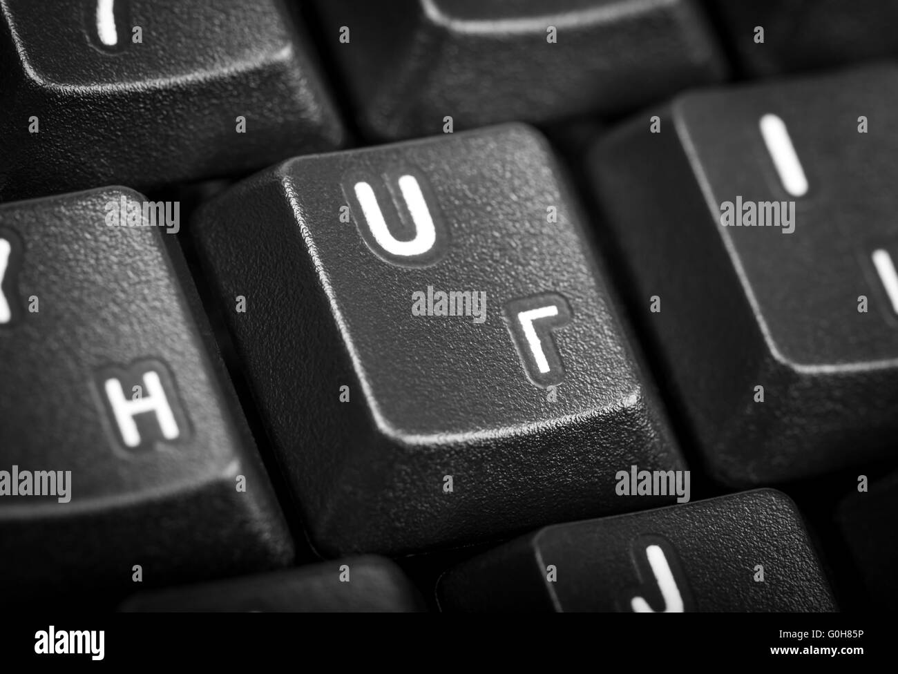 Detail black computer keyboard with russian letter. Focus on the center key. Stock Photo