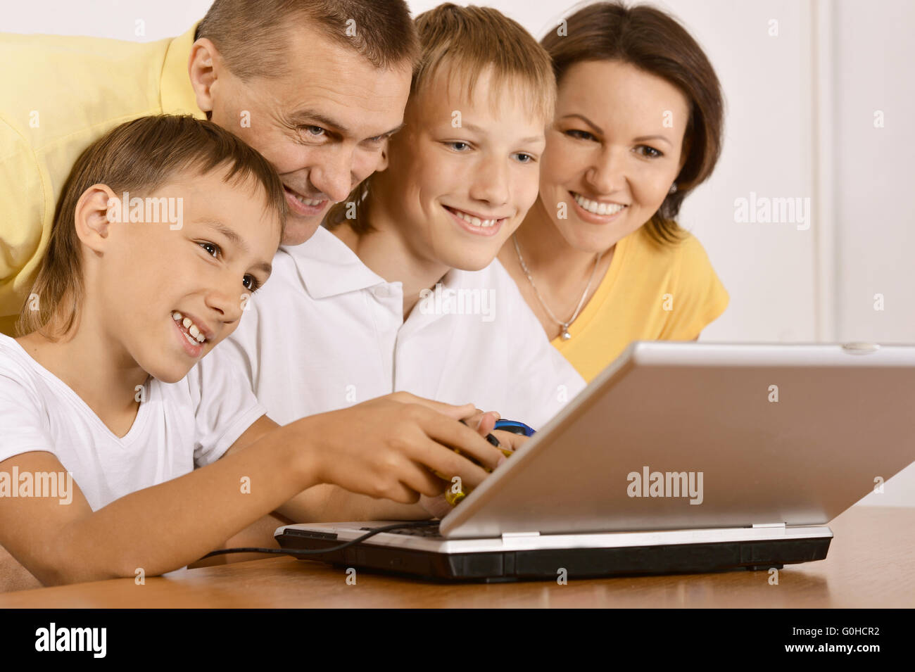Happy family with laptop Stock Photo - Alamy