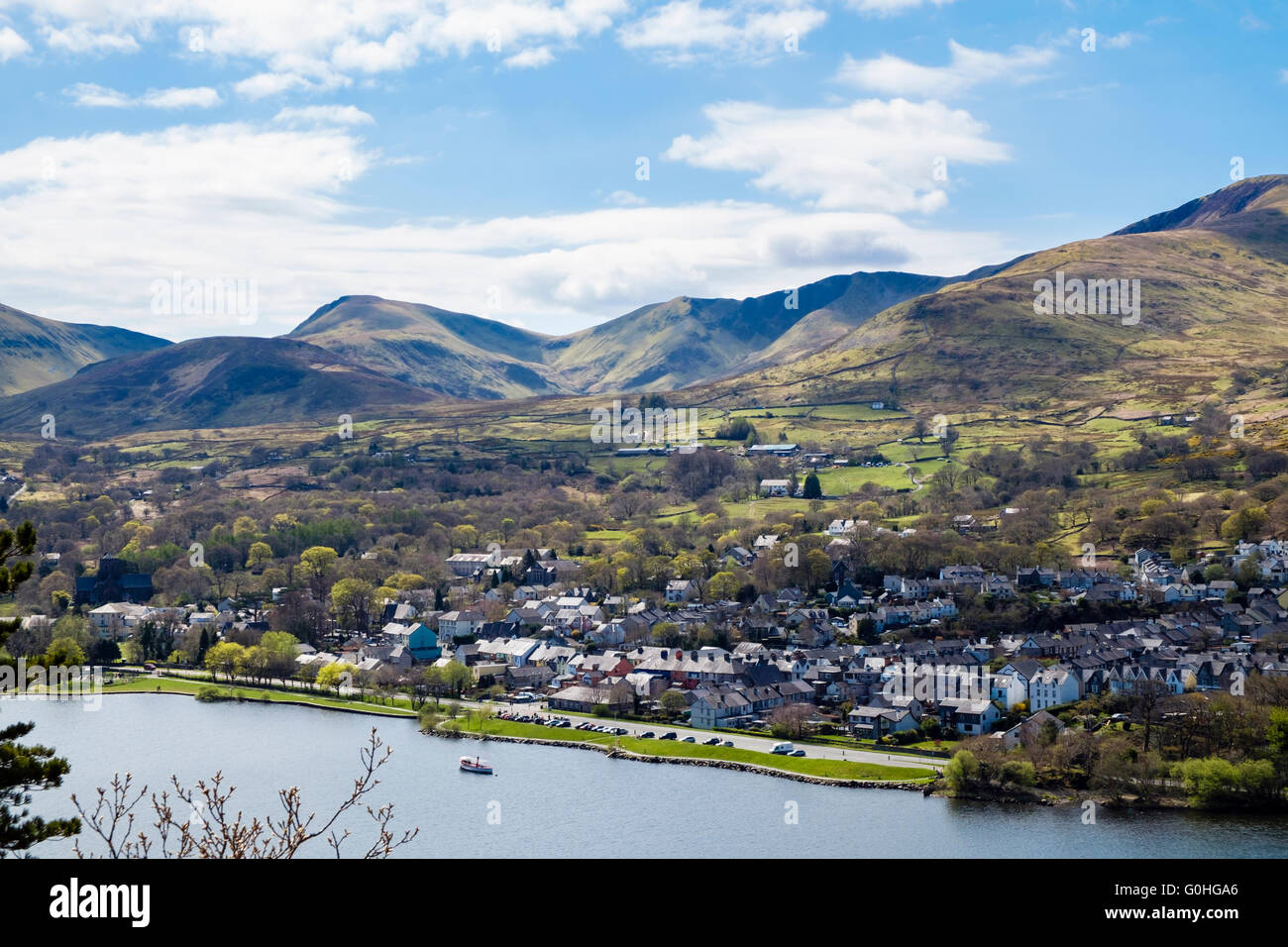 High view across Llyn Padarn lake in Padarn Country Park to Llanberis village surrounded by mountains of Snowdonia Wales UK Stock Photo