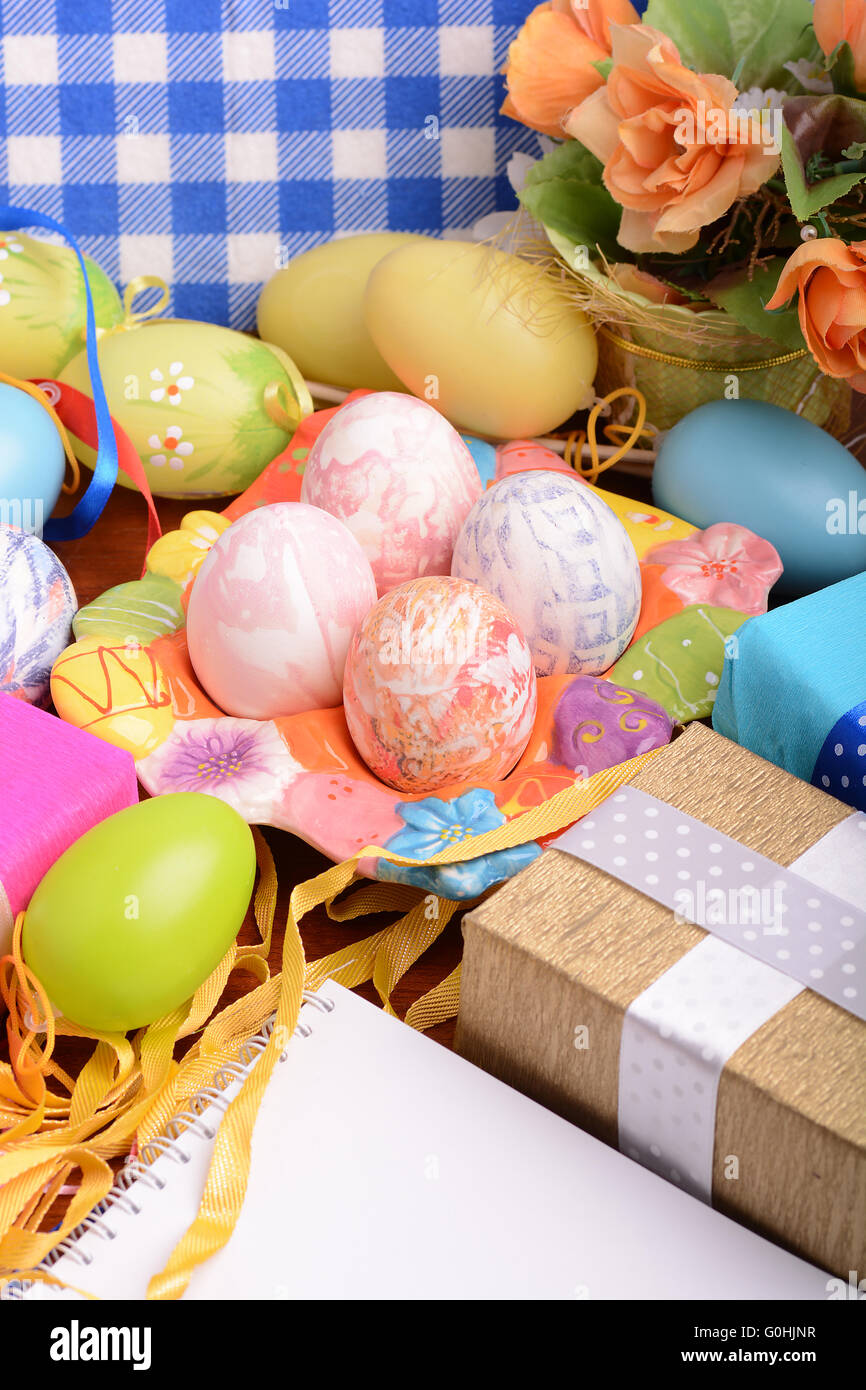 Easter background with colorful eggs and yellow tulips over white wood ...