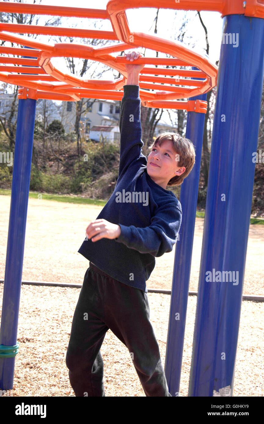 Boy climbing on playground equipment Stock Photo Alamy