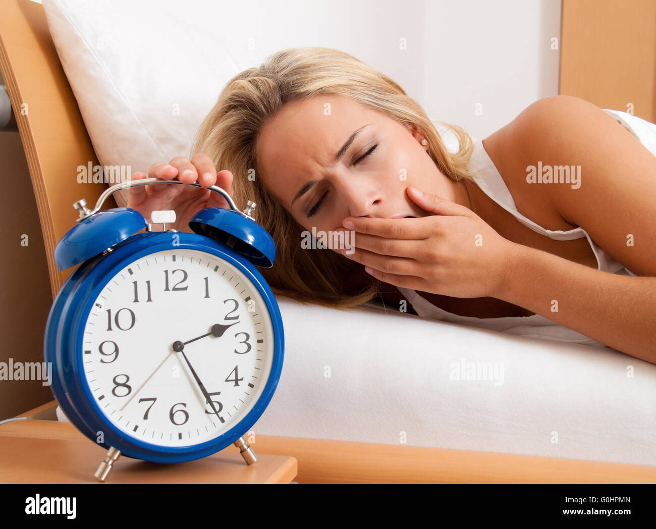 Clock with sleepless at night. Woman can not sleep. Stock Photo