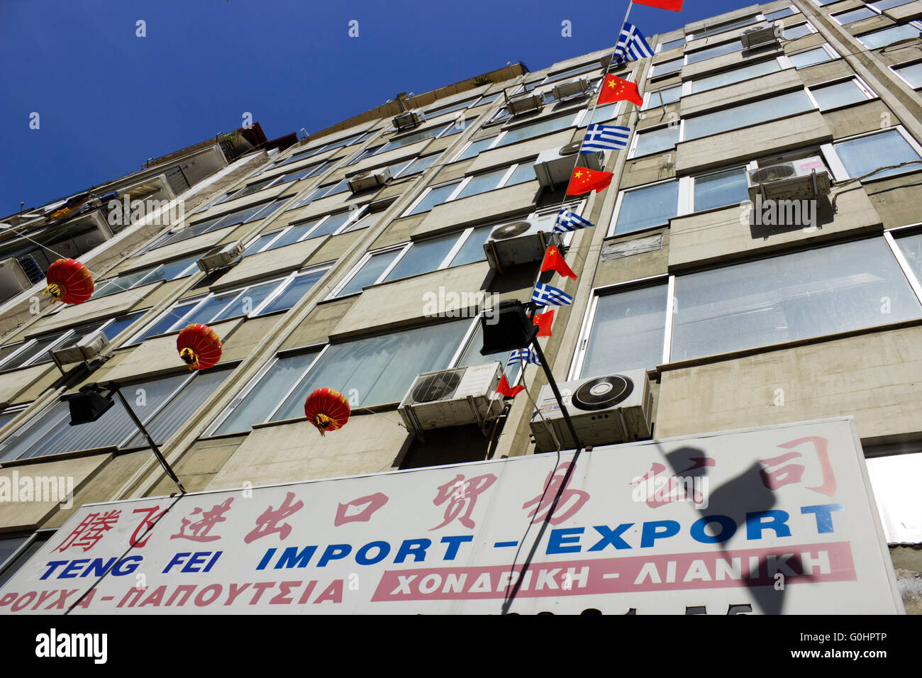 Billingual Greek-Chinese advertising shop sign and red overhead lanterns  ornaments & country flags China town, Thessaloniki Stock Photo - Alamy