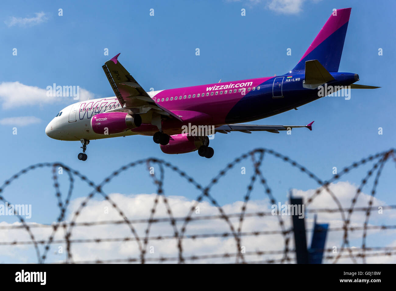 Wizz Air, Airbus A320 plane approaching for landing to airport Prague, Czech Republic Razor wire fence Stock Photo