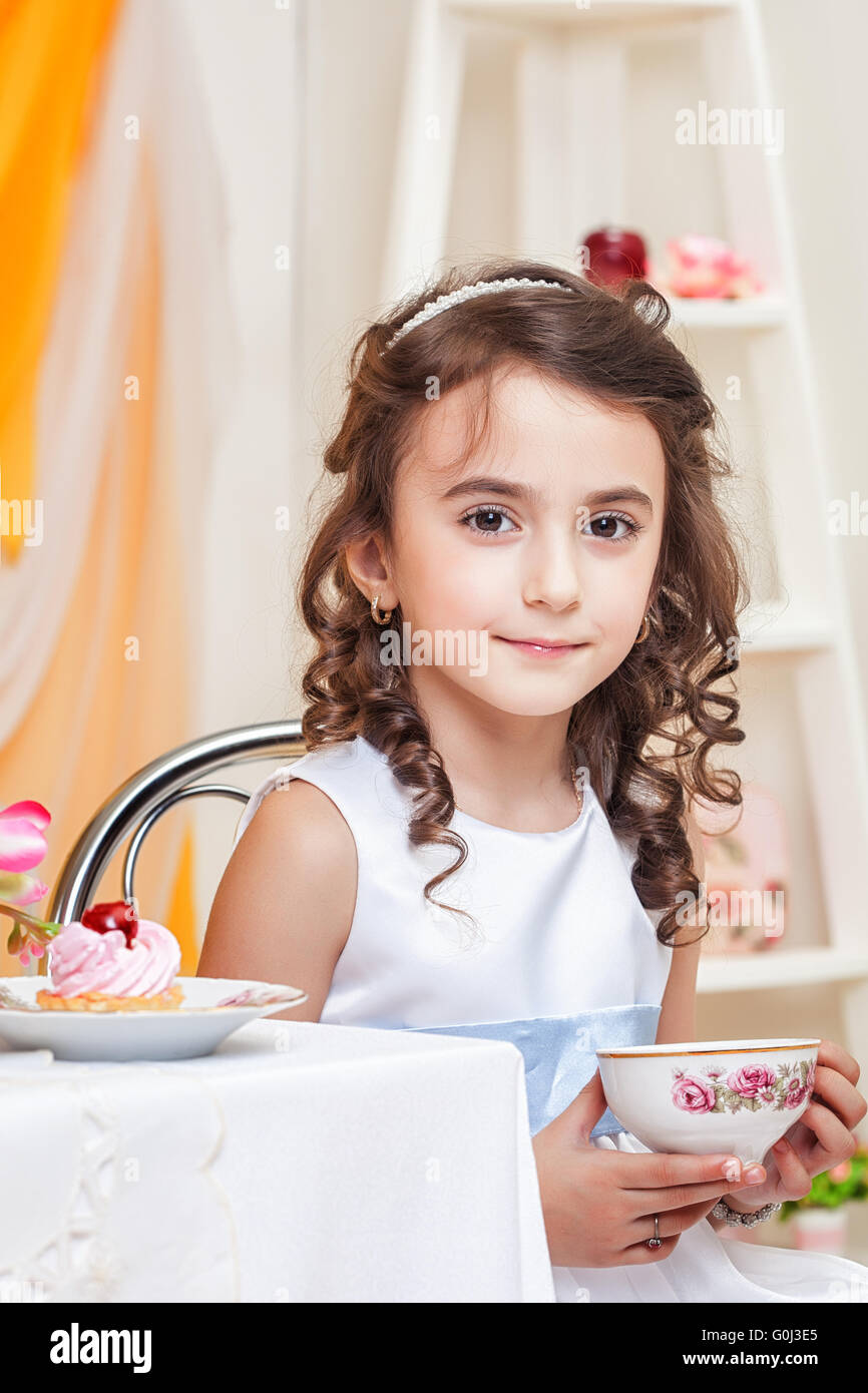 Beautiful browneyed girl drinking tea with sweets Stock Photo Alamy
