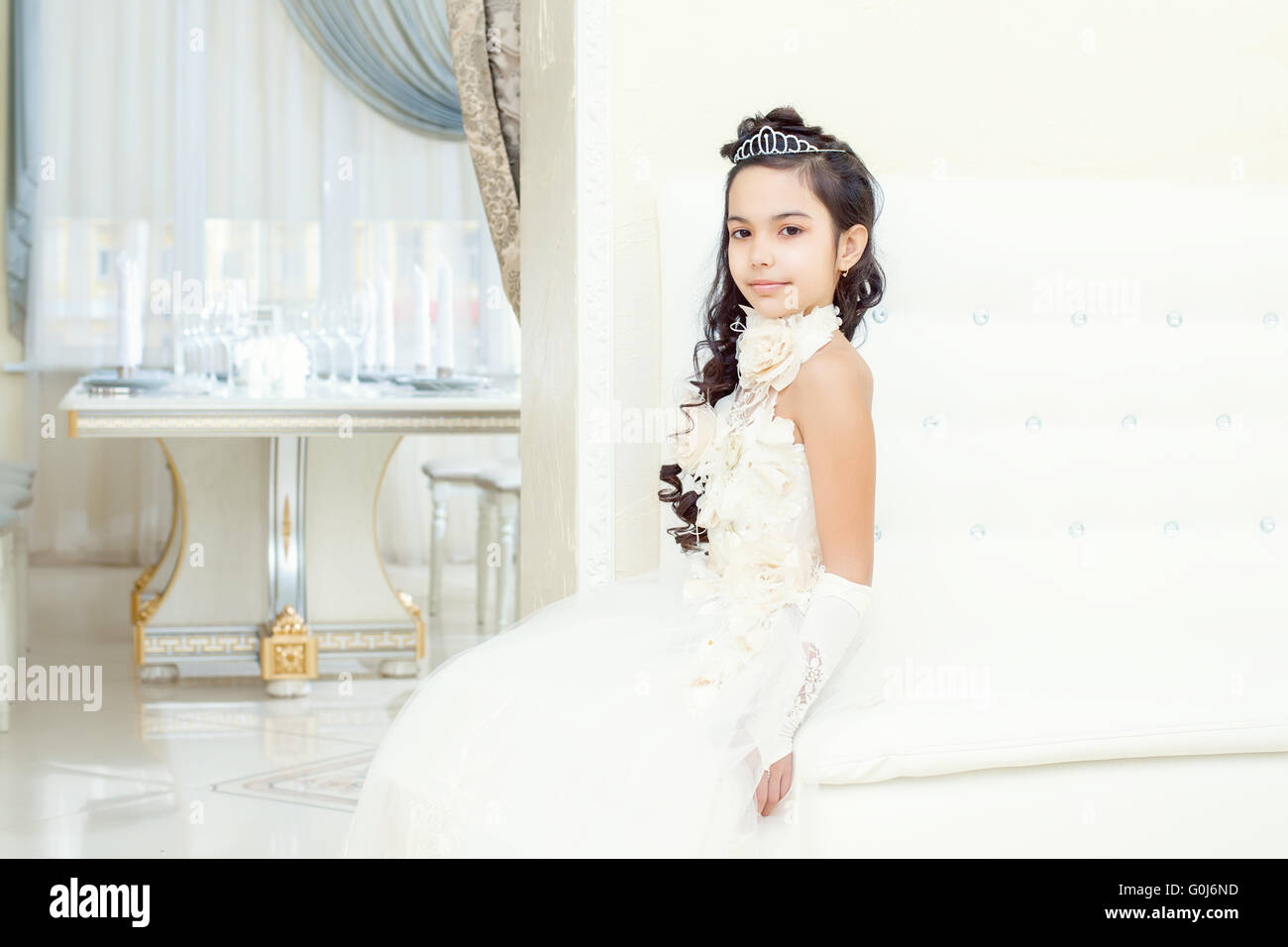 Lovely little girl posing in white luxurious dress Stock Photo - Alamy