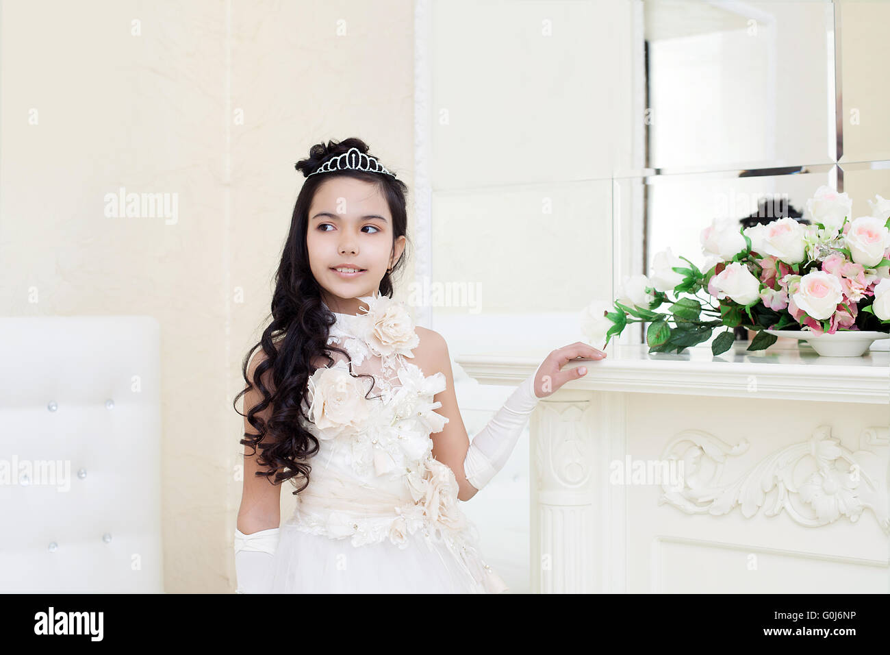 Lovely tanned girl posing in elegant white dress Stock Photo