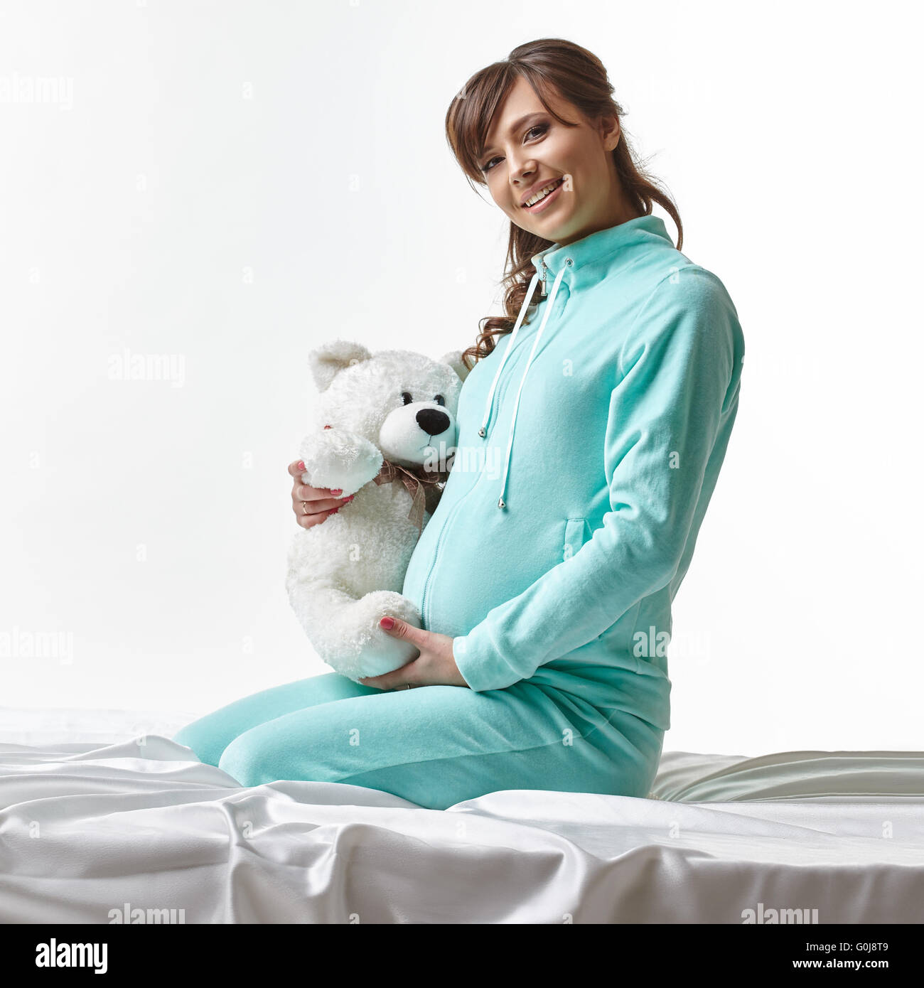 Happy expectant mother in casual clothes with toy Stock Photo