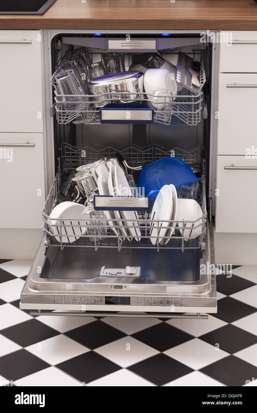 Dishwasher loades in a kitchen with clean dishes Stock Photo